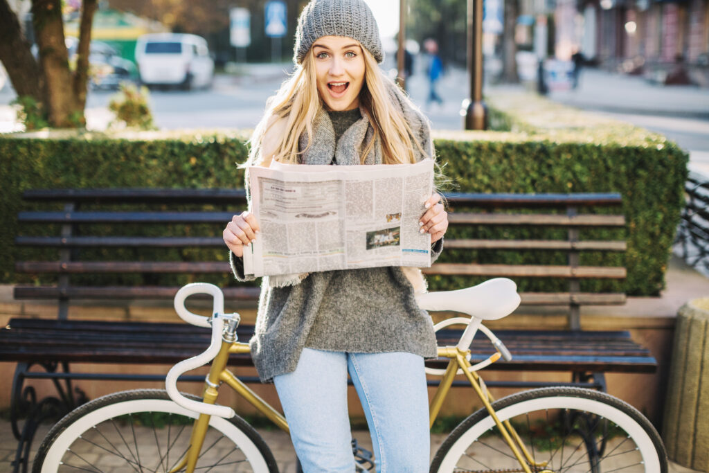 un femme avec un journal sur un vélo