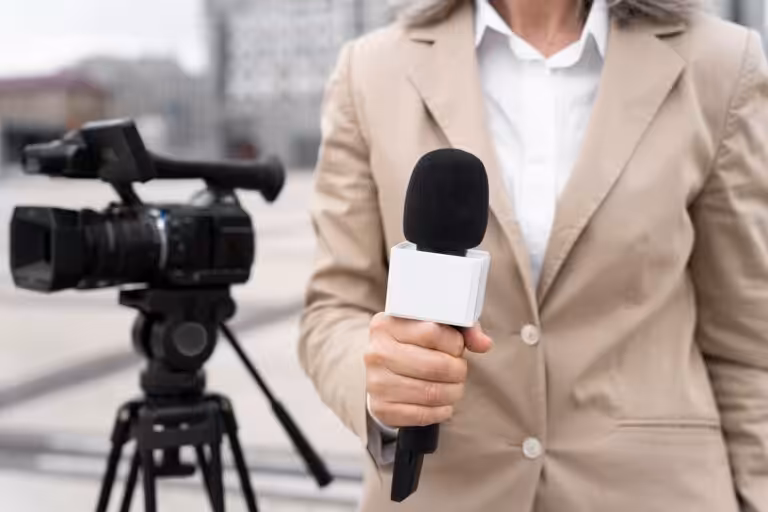 Journaliste avec microphone devant caméra