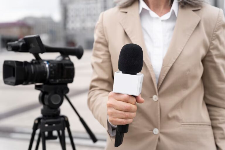 Journaliste avec microphone devant caméra