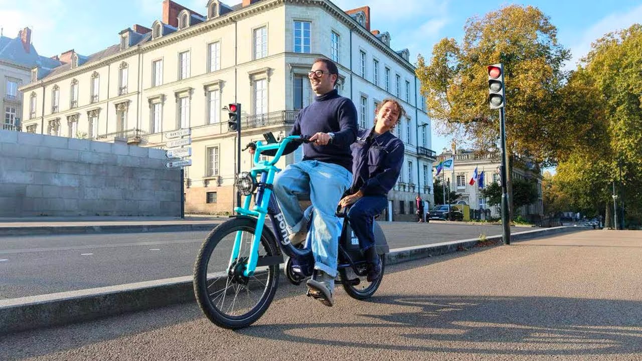 Deux jeunes à vélo dans la rue en France.