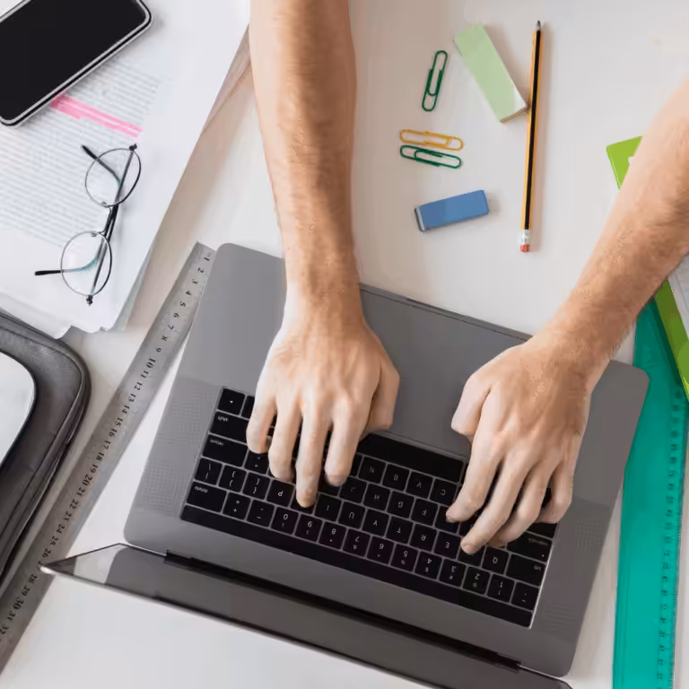 main sur un ordinateur avec des éléments de papeteries