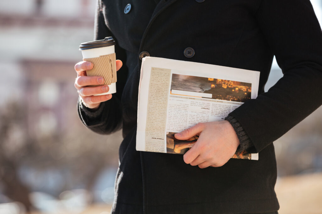 un homme avec un journal et un café