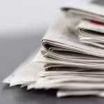 closeup shot several newspapers stacked top each other